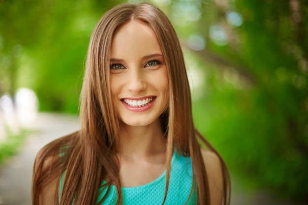 Garota em local verde sorrindo