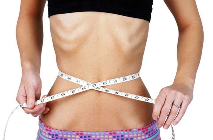 barriga feminina e fita métrica